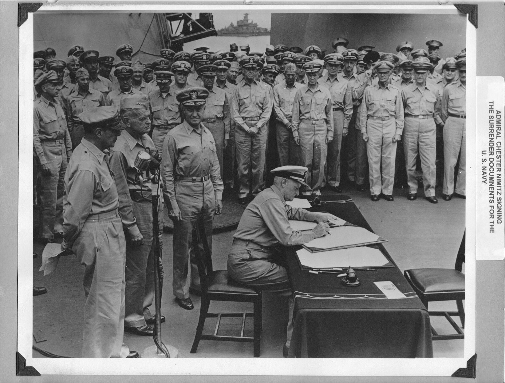 Admiral Chester Nimitz signs the surrender documents